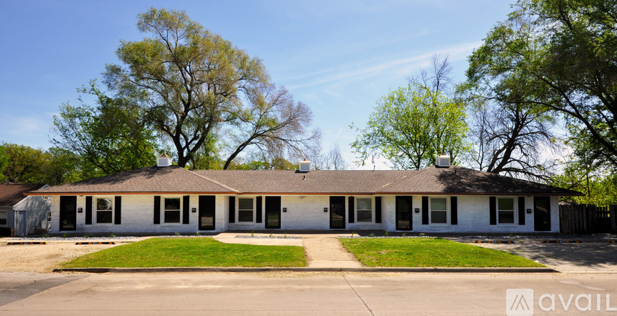 A white building with a green lawn in front.