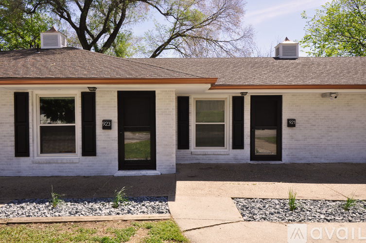 A house with a white facade and black shutters is for sale.