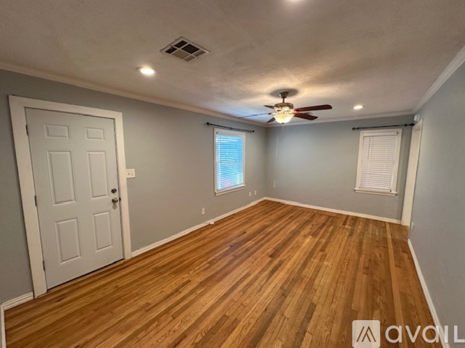 A room with wooden flooring and a ceiling fan.