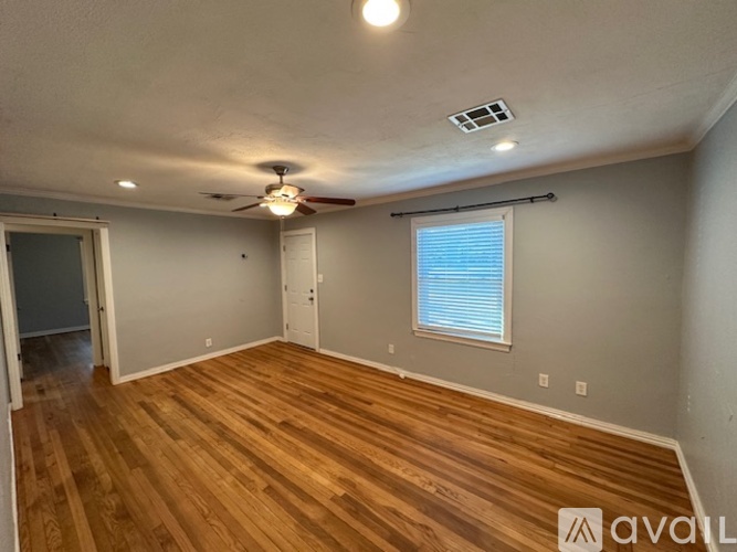 A room with wooden flooring and a ceiling fan.