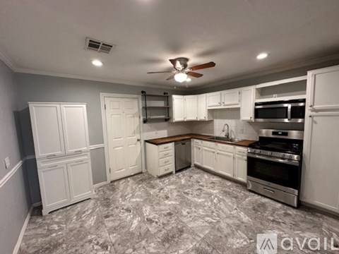 A kitchen with a marble floor and white cabinets.