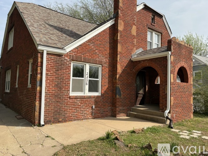 A red brick house with a white door and windows.
