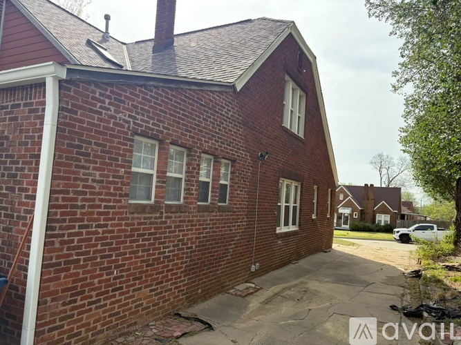 A red brick house with a white door and windows.
