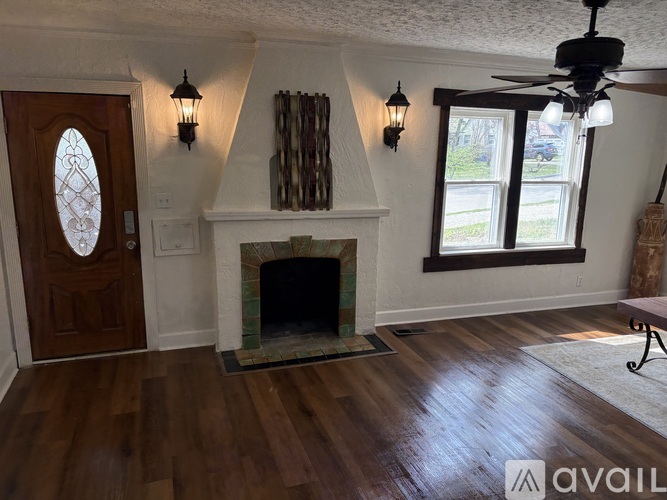A living room with a fireplace and a ceiling fan.