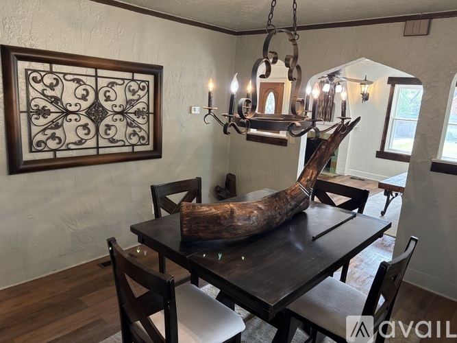 A dining room with a wooden table and chairs and a decorative piece on the table.