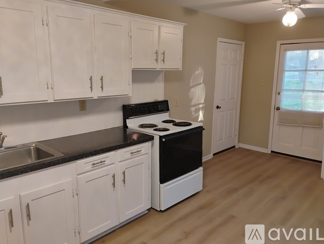 A kitchen with white cabinets and a black stove top oven.