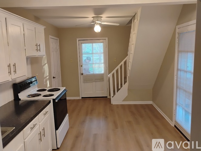 A kitchen with white cabinets and a black stove top oven.
