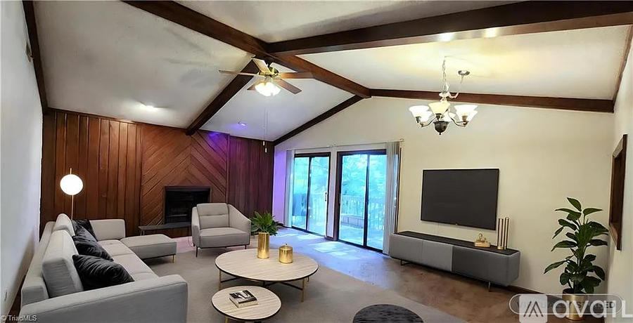 A living room with a grey couch, a white coffee table, and a flat screen TV.