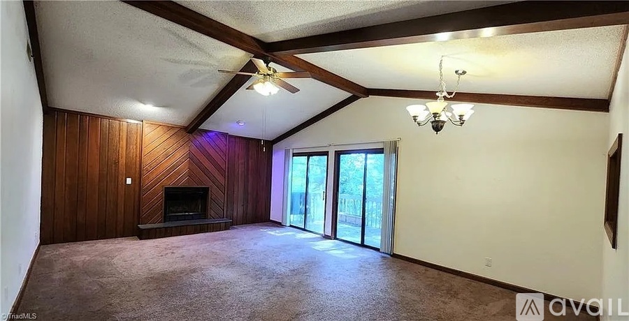 A spacious room with a fireplace and sliding glass doors.