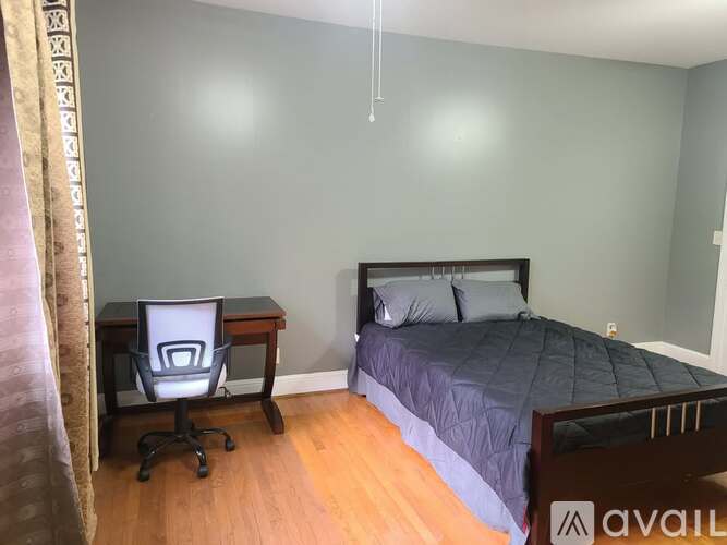 A bedroom with a bed, desk, and chair.