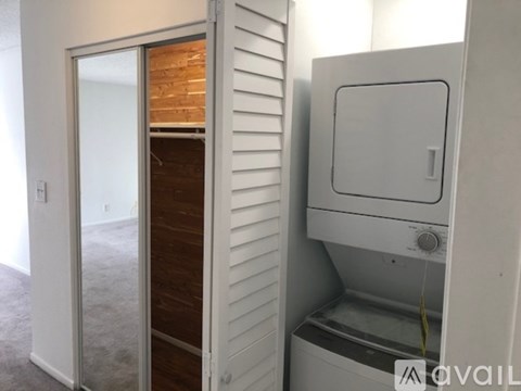 A washing machine is built into a wall in a room.