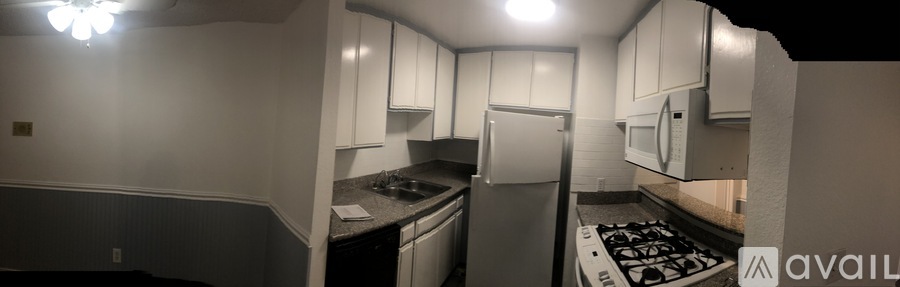 A kitchen with white cabinets and a stove top oven.