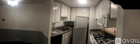 A kitchen with white cabinets and a stove top oven.