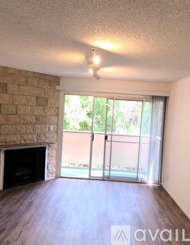 A room with a fireplace and sliding glass doors leading to a balcony.