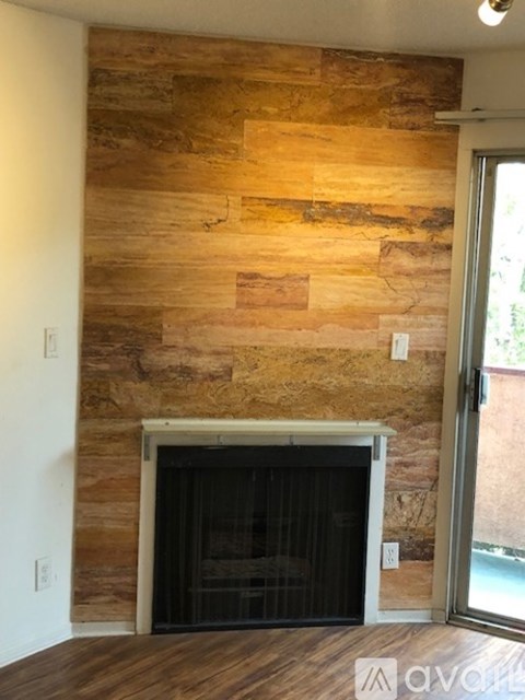 A room with a stone wall and a fireplace.