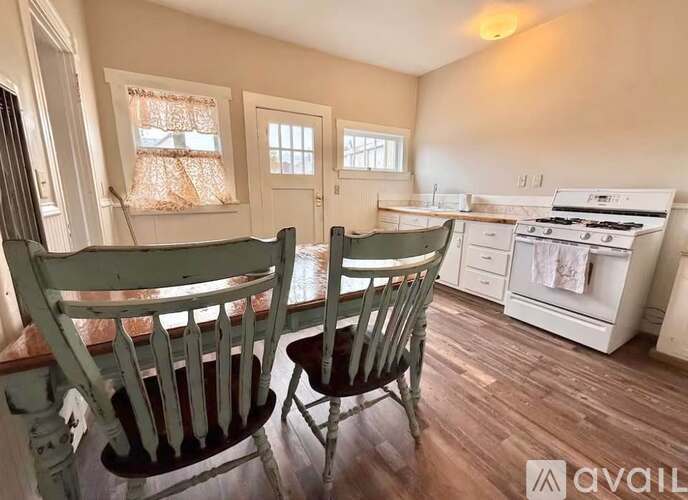 Two chairs are placed in a kitchen with wooden floors.