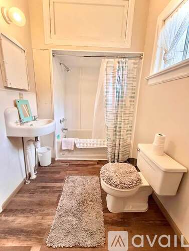 A bathroom with a toilet, sink, and bathtub.