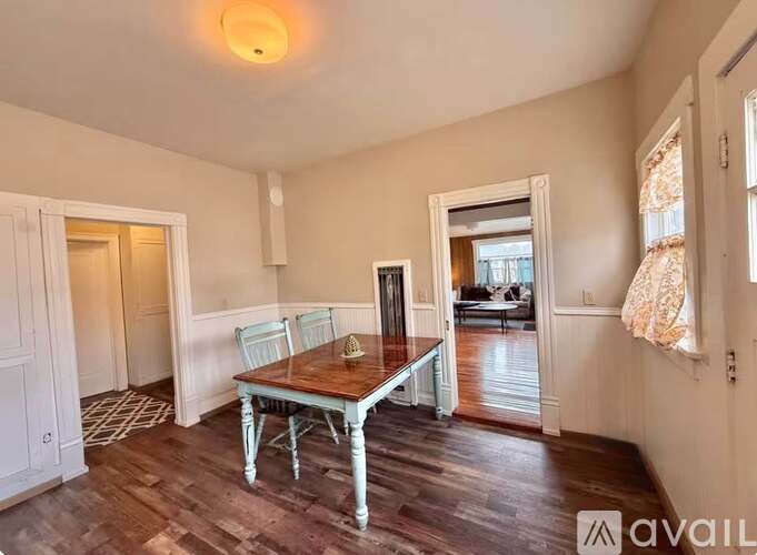 A dining room with a wooden table and chairs.