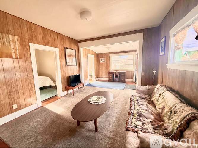 A living room with a couch, coffee table, and television.