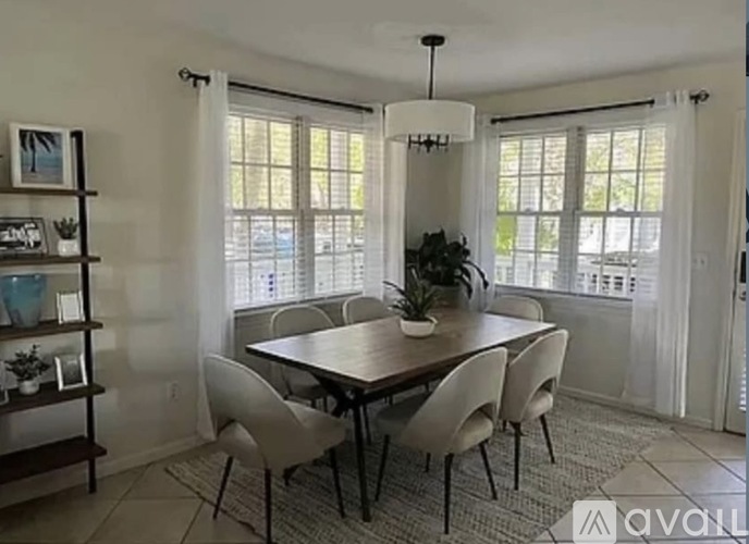 A dining room with a table and chairs.