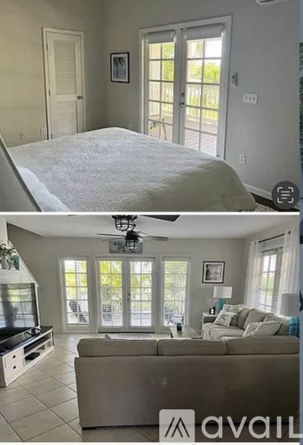 A bedroom with a bed and a living room with a couch and a television.
