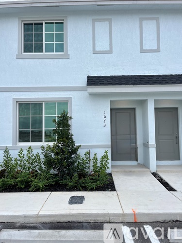 A white house with a grey door and windows.