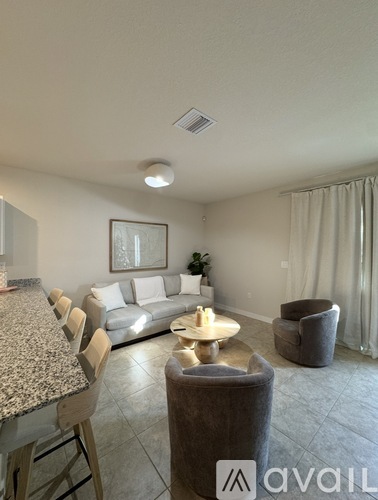 A living room with a granite countertop and a grey sofa.