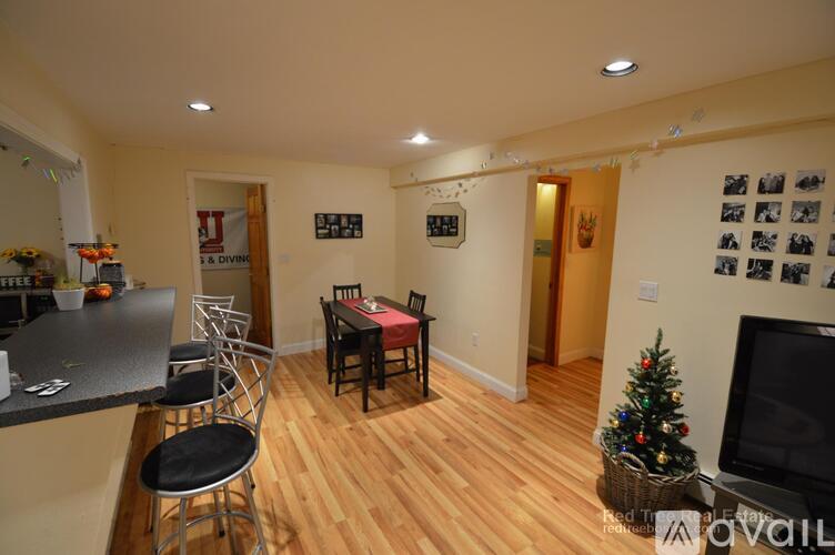 A living room with a Christmas tree and a fireplace.