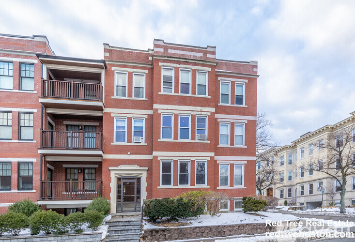 A red brick building with a balcony on the second floor.
