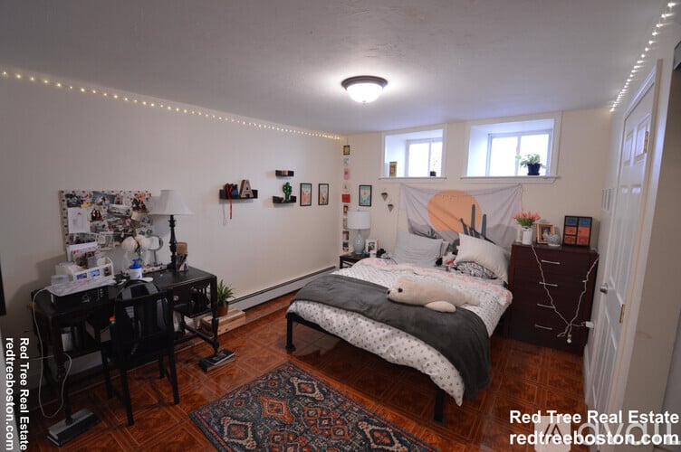 A bedroom with a bed, desk, and chair.