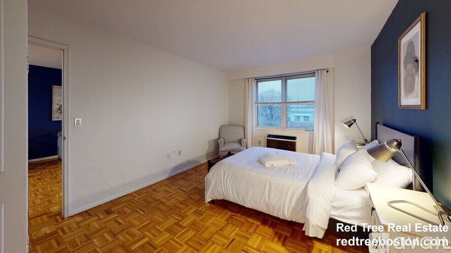 A bedroom with a bed, a window, and a lamp.