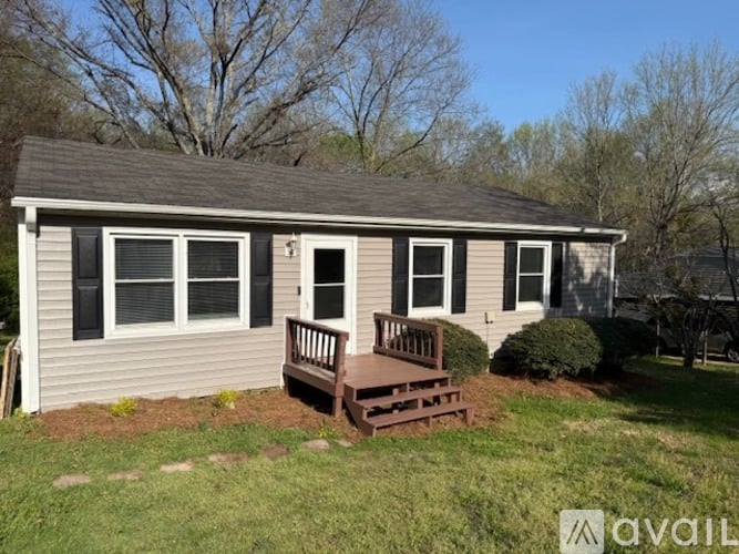 A small house with a porch and a brown deck.