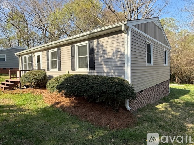 A house with a grey siding and a small porch.