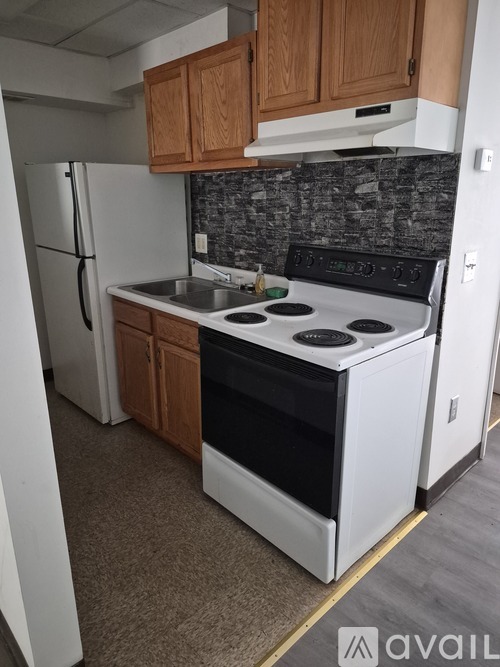 A kitchen with a white stove top oven and a white refrigerator.