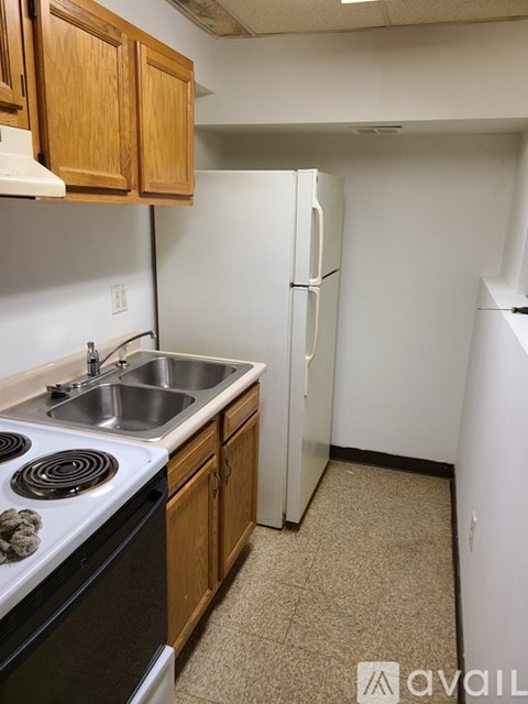 A kitchen with a stove, sink, and refrigerator.