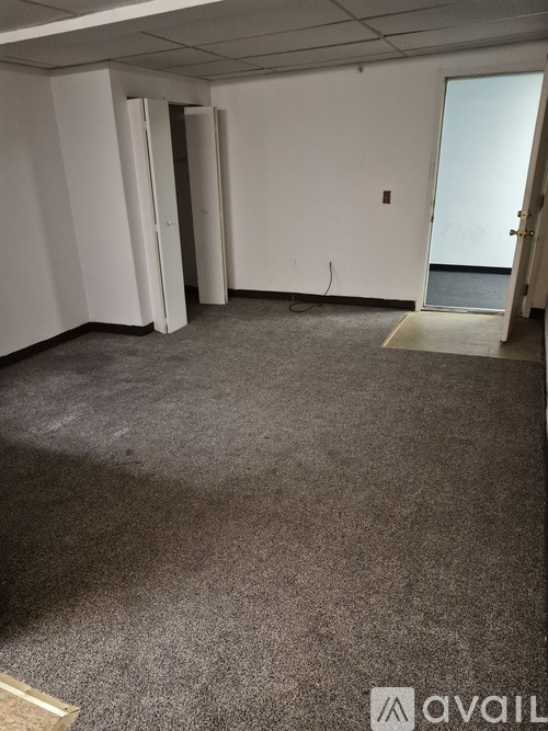 A room with a carpeted floor and a door leading to a balcony.