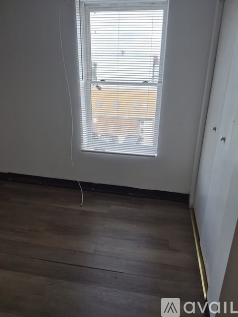 A room with a carpeted floor and a door leading to a balcony.