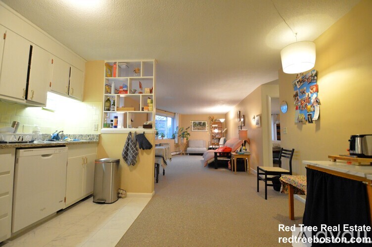A kitchen with white appliances and a dining area with a table and chairs.