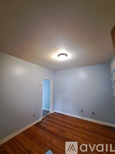 A room with wooden floors and a white ceiling with a light fixture.