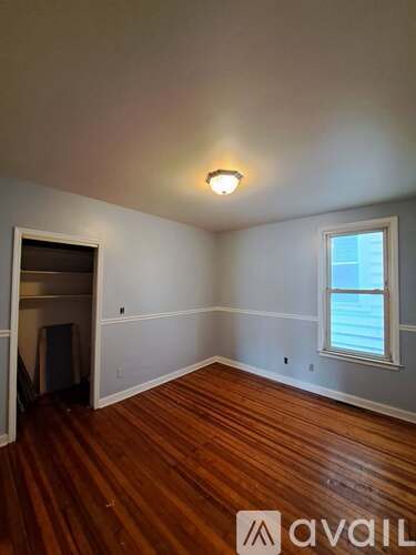 A room with wooden floors and a window.