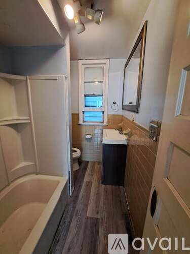 A bathroom with a tub, toilet, and sink.