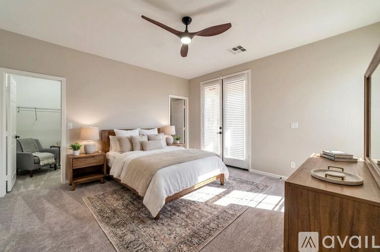 A bedroom with a large bed and a ceiling fan.
