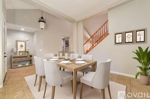 A dining room with a wooden table and chairs.