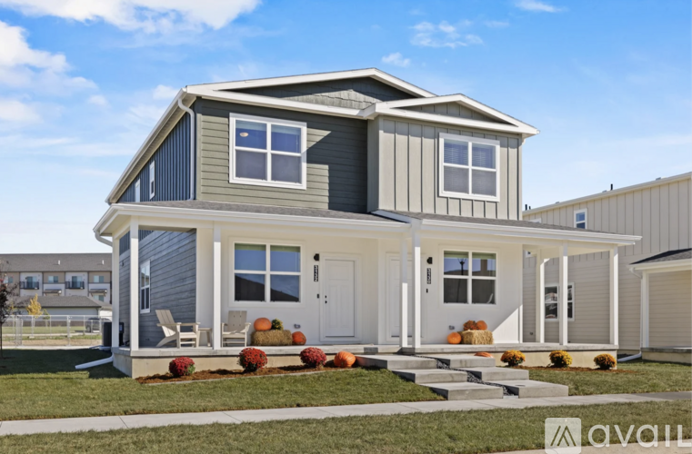 A modern house with a grey and white exterior and a front porch.