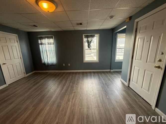 A room with wooden flooring and white doors.