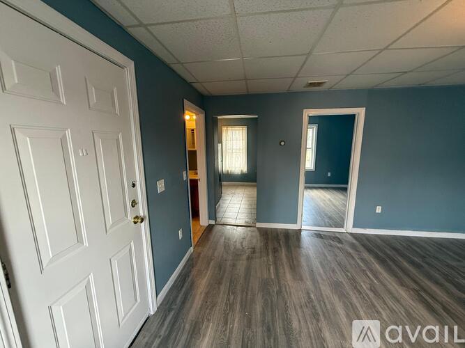 A room with a white door and a wooden floor.