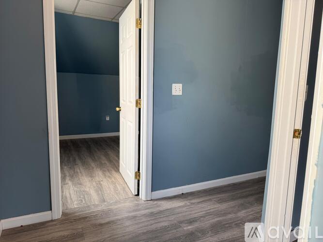 A room with a white door and a light switch on the wall.