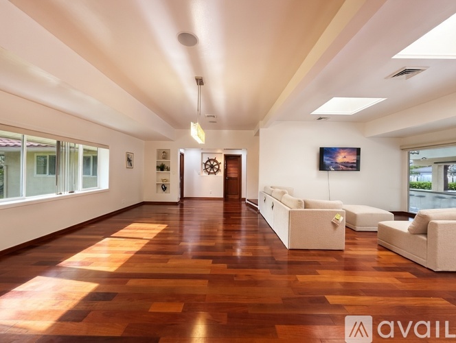 A spacious room with wooden floors and white walls.