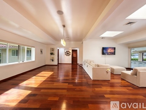 A spacious room with wooden floors and white walls.