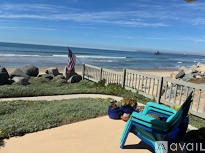 A blue chair is in the foreground of a beach scene.